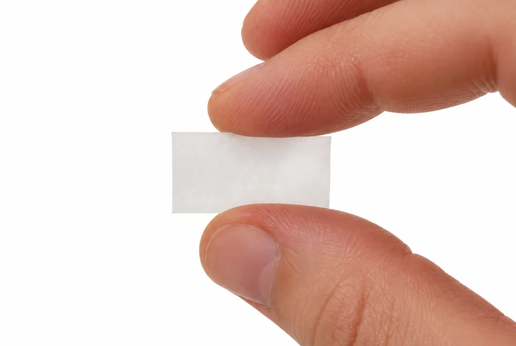 A SENO film strip held between two fingertips